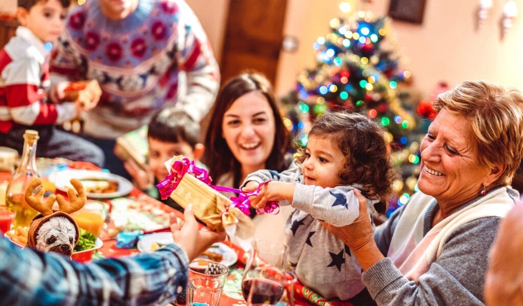 children opening gifts by christmas tree